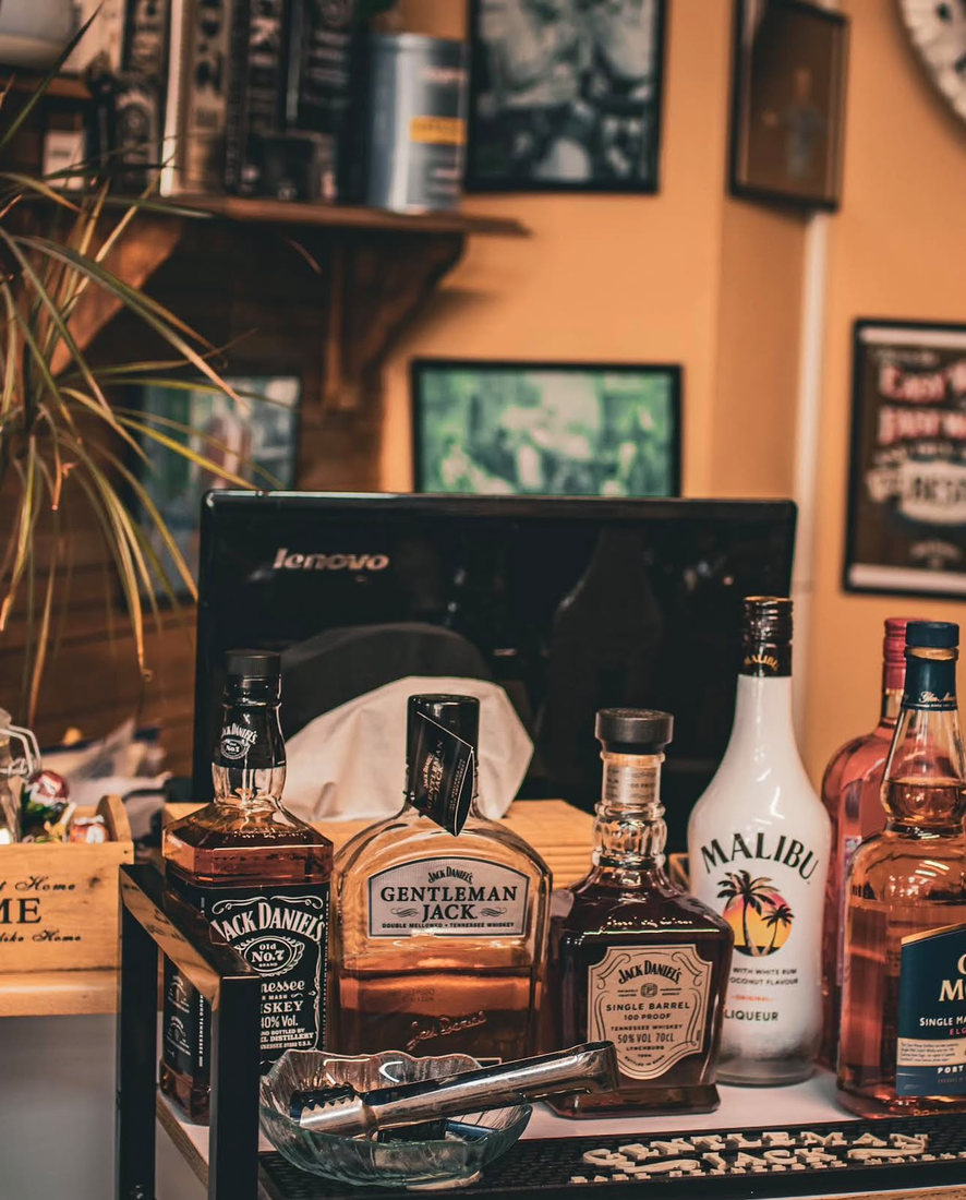 Bottles of Jack Daniel's, Gentleman Jack and Single Barrel lined along the counter in front of framed black and white prints